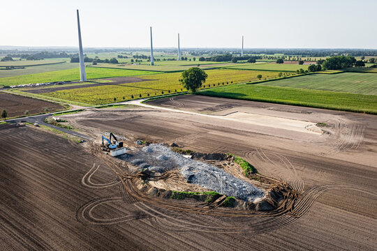 Repowering beim Windstrom - Schuttberg eines gesprengten Windrades, daneben ein Bauplatz f&uuml;r eine neue Windkraftanlage.