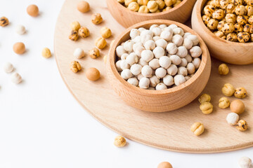 Crispy white roasted chickpeas in a bamboo bowl on a wooden tray