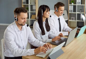 Team of call center operators in headsets works together in modern office, providing reliable customer support and service. Agents demonstrate clear communication and professional efficiency.