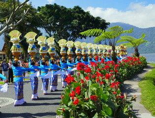 herrlicher geschmückter Festumzug der Frauen beim Bratan -Tempel in Bali mit Opfergaben und roten...
