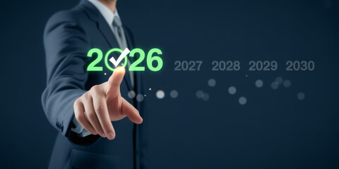 Businessman selecting 2026 with a checkmark planning for future years and forecasting business growth