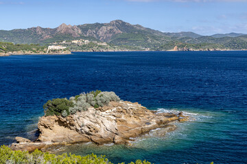 Scenic coastal view of Elba Island, Italy with turquoise sea, small rocky islet, and Mediterranean landscape