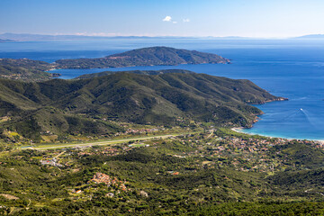 Breathtaking view of Elba Island from mountain vantage point overlooking the sparkling sea, lush green landscape, rocky coastlines, clear blue waters