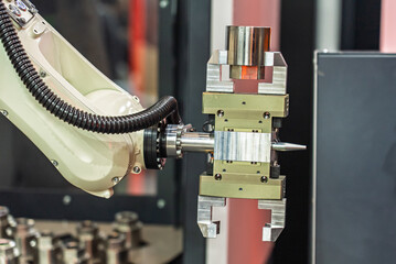 Drawer with CNC details. The robot arm places part and shafts on a pallet. Production automation. Robotic inspection arm analyzing machined components for quality control