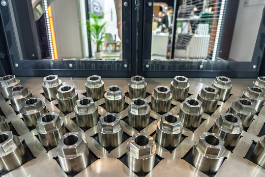 Drawer with CNC details. The robot arm places part and shafts on a pallet. Production automation. Robotic inspection arm analyzing machined components for quality control