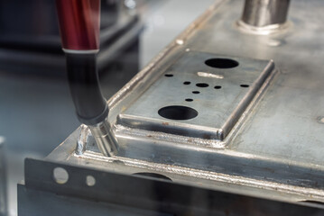 Robot welds steel. Welding head. Weld robot. CNC welding. Robotization and automation of the weld process. Robot welding steel. Industrial welding robot and working with metal parts