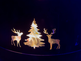 Rustikale Metallfeuerstelle mit ausgeschnittenen Hirsch- und Tannensilhouetten, brennendes Feuer im Inneren, perfekte Outdoor-Dekoration für gemütliche Abende im Garten oder auf der Terrasse