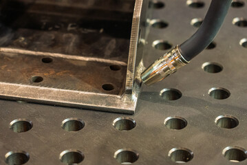 Robot welds steel. Welding head. Weld robot. CNC welding. Robotization and automation of the weld process. Robot welding steel. Industrial welding robot and working with metal parts