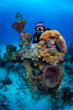 Buzo con antigua ancla en el fondo del oceano