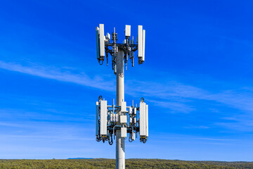 Drone aerial photograph of the top section of a large Cellular Tower against a bright blue sky background in the Blue Mountains, New South Wales, Australia.