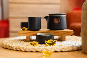 Tea set with Chinese symbols on table in room decorated for New Year celebration, closeup