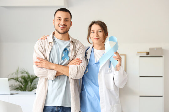 Young man and female urologist with blue ribbons in clinic. Prostate cancer awareness concept - Powered by Adobe