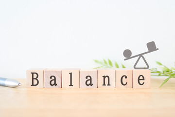 バランスを示す木製ブロックとシーソーのイラスト。