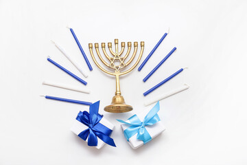 Composition for Hanukkah celebration with menorah, candles and gift boxes on light background