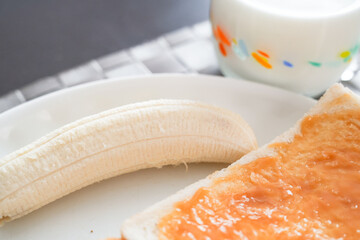 白い皿に並んだバナナとトーストの朝ごはん