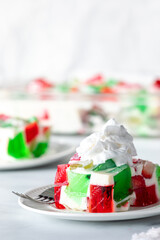 A serving of homemade gelatin dessert topped with a dollop of whipping cream.