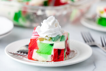 A serving from a homemade gelatin dessert, topped with whip cream. 
