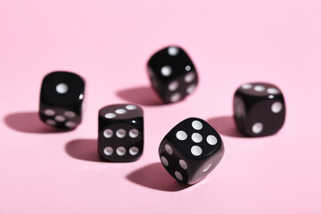 Black game dices on pink background
