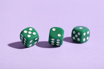 Green game dices on lilac background