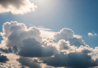 A high-resolution photograph of a bright blue sky filled with soft, fluffy cumulus clouds. The clouds appear voluminous and scattered across the horizon, illuminated by natural sunlight. Captured from
