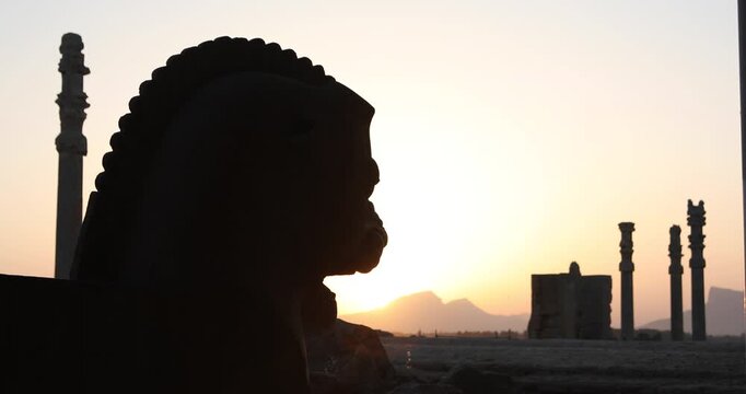 Silhouetted winged bull capital and ancient columns of Persepolis at sunset as the sun drops behind the Zagros. A quiet frame of heritage, empire and endurance across Iran&rsquo;s desert horizon.