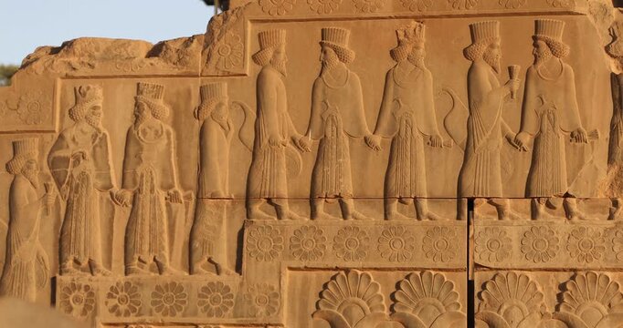 Warm raking light reveals a Persepolis relief of Persian dignitaries in procession&mdash;carved robes, curled beards, lotus and rosette borders. Achaemenid ceremony and craftsmanship preserved in stone.