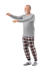 Senior male sleepwalker in pajamas on white background