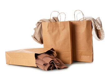 Paper shopping bags with sweater and stylish jackets on white background