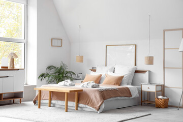 Interior of stylish hotel room with folded bathrobes on cozy bed