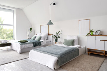 Interior of stylish hotel room with houseplants and cozy beds