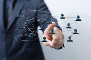A close-up of a businessman's finger touching a network, representing teamwork, communication, and digital connections.