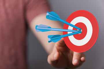 Hand pointing towards a target with arrows. Symbolizes achievement, goals, business, success, focus, strategy, and aiming. Perfect for illustrat