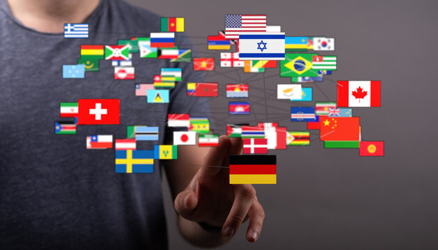 A person's hand interacting with a network of global flags, symbolizing international connection, globalism, and communication across borders.