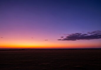 Obraz premium Dramatic sundown over a flatland, vibrant sky above the horizon line