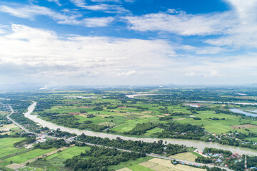 Naklejka premium Top view of the Sakae Krang River, Uthai Thani Province where both sides of river are filled with lush green trees. There are community near waterside.