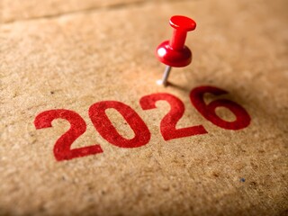 Red pushpin marking the year 2020 on a textured surface representing time and planning