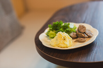 Selected focus on mash potato with sausage and vegetable in a plate salad on table.