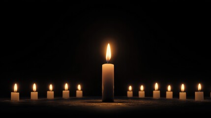 A line of candles lit in darkness, with the light emitting from candles giving the picture a warm glow