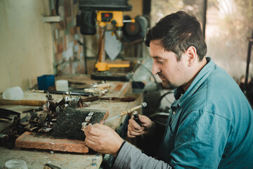 Latino man working in his workshop. Knife maker.