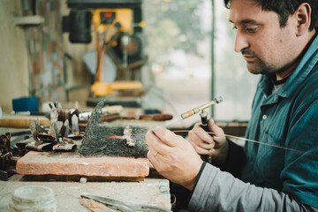 Latino man working in his workshop. Knife maker.