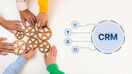 Obraz premium Diverse hands gather around wooden gears, symbolizing teamwork and collaboration in a business setting, with a digital CRM interface suggesting modern strategies. Raster