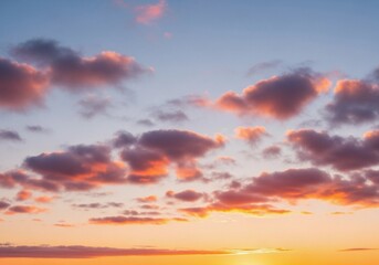 A peaceful evening sky with scattered cumulus clouds glowing in warm orange, pink, and light blue hues. The sun sets below the horizon, casting soft light rays upward. Captured in full HD from a groun
