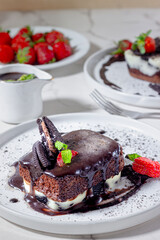 Delicious Oreo Chocolate Cake with Cream Cheese Frosting and Fresh Strawberry on White Plate