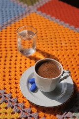 Delicious turkish coffee served with water on a colorful blanket
