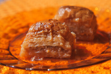 Delicious baklava dessert on bright orange plate