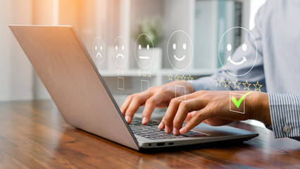 A person using a laptop to rate customer satisfaction with five-star feedback, showing online service quality, user experience, digital communication, and business review for marketing and improvement