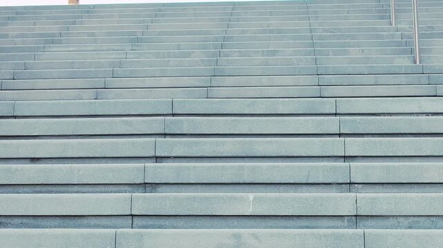 Empty, extended concrete staircase featuring curbstone-style steps. Horizontal stairway ascends from an underground level, offering an upward view. Staircase is constructed from solid cement concrete