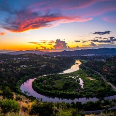 Scenic landscape featuring river winding through rolling hills during sunset