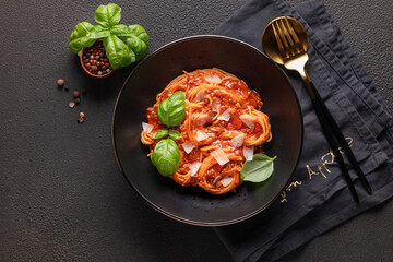 Pasta Spaghetti Bolognese in black bowl on dark background. Bolognese sauce is classic italian cuisine dish. Popular italian food. Top view