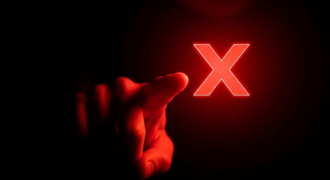 Hand presses a glowing red x symbol in the darkness, representing denial and negativity with a sense of urgency and warning.